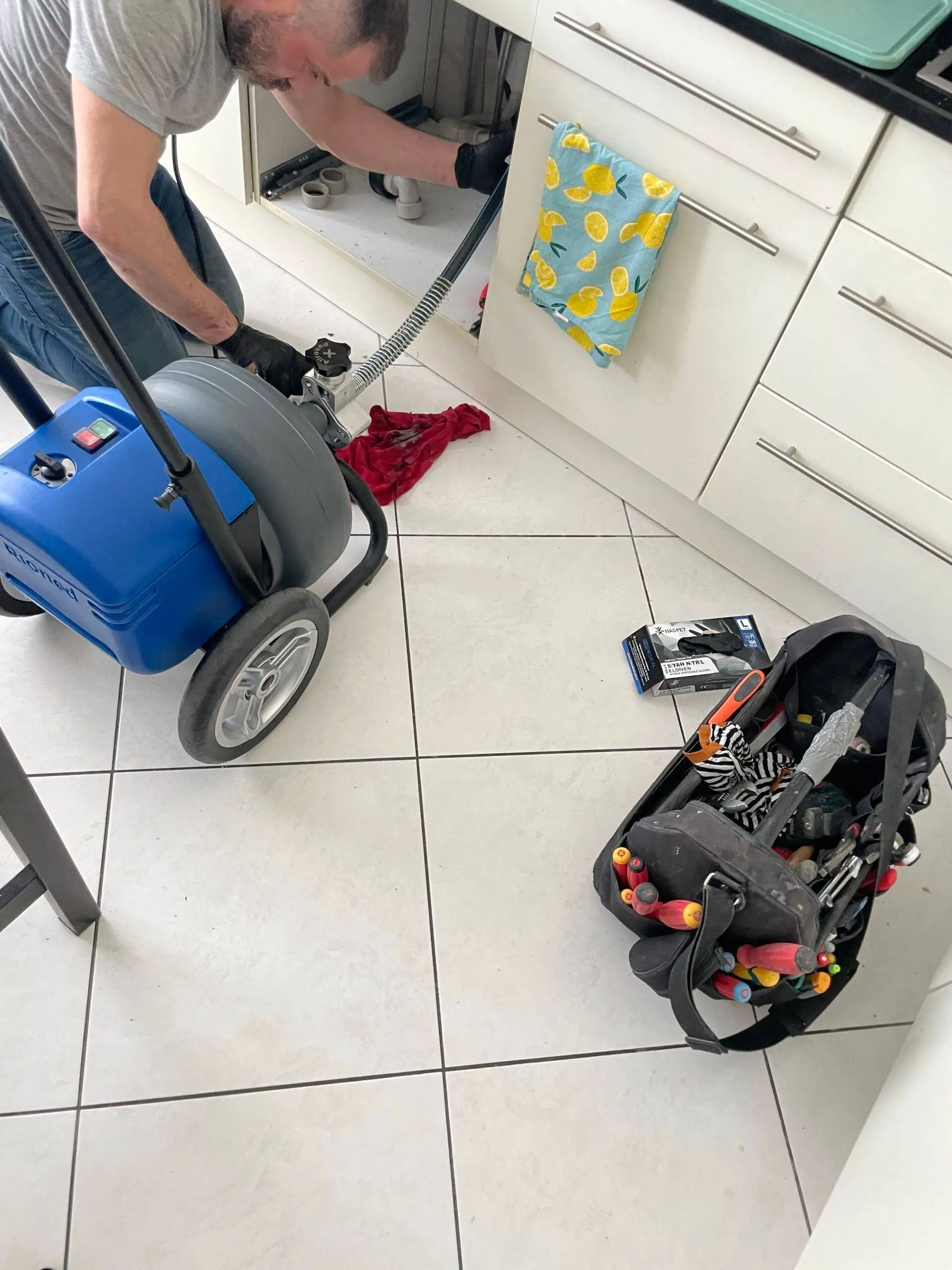 Machine de débouchage et sacoche d’outils dans une cuisine