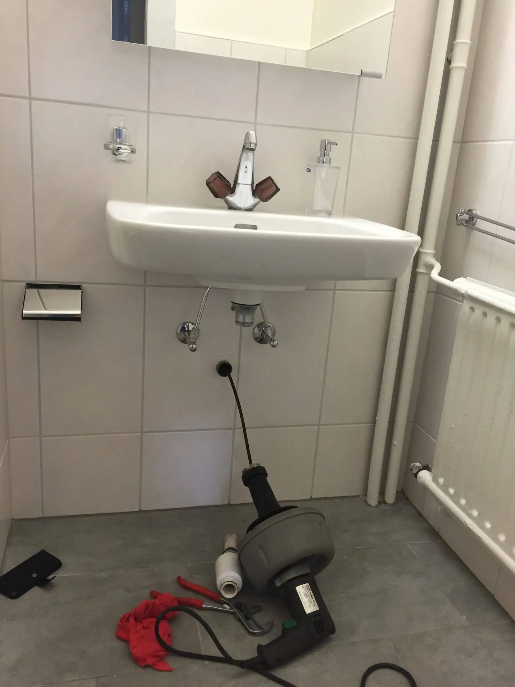 Furet de débouchage engagé dans l’écoulement d’un lavabo