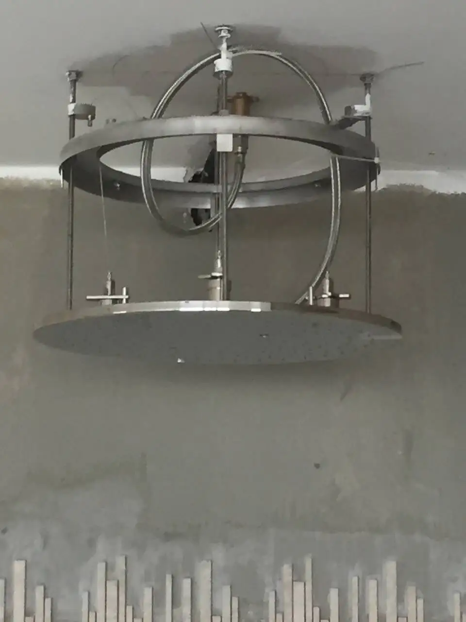 Pose d’une pomme de douche de plafond sur son support, avant finitions